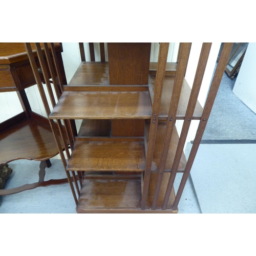 41 - An Edwardian oak revolving bookcase with slatted sides, on platform feet  43