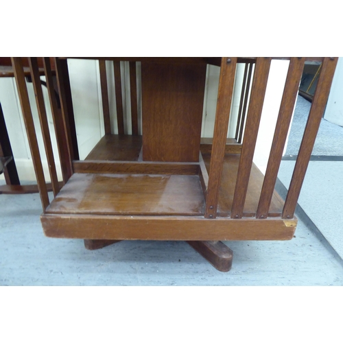 41 - An Edwardian oak revolving bookcase with slatted sides, on platform feet  43