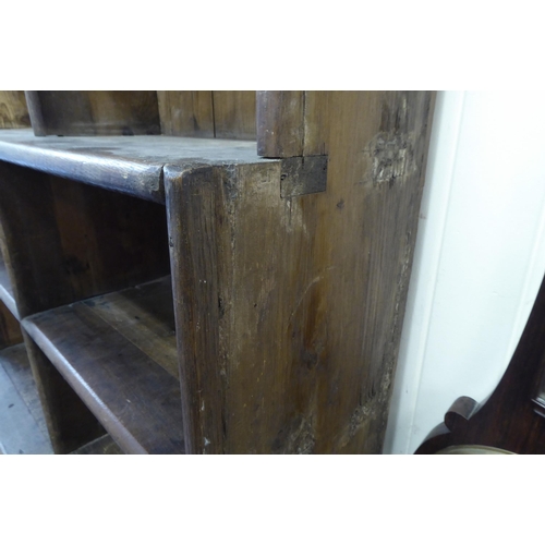 45 - A 20thC rustic oak three tier waterfall front bookcase, on a plinth  83