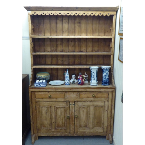 59 - A 20thC reconstituted pine, one piece dresser with three open shelves, over two drawers and two door... 