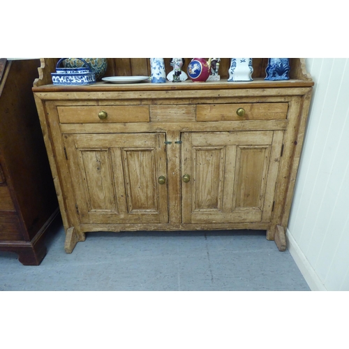 59 - A 20thC reconstituted pine, one piece dresser with three open shelves, over two drawers and two door... 