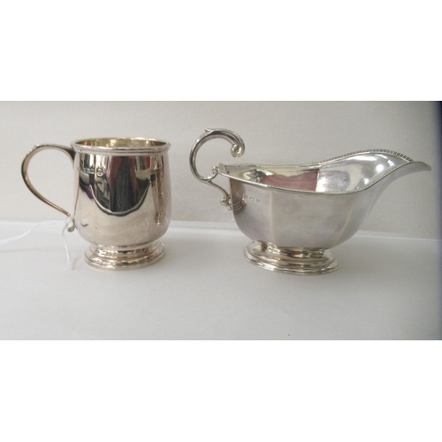 76 - A silver Christening mug with an applied wire rim and C-scroll handle, on a pedestal footrim; and a ... 