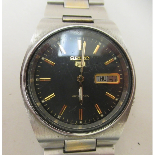 150 - A Seiko 5 automatic wristwatch, faced by a baton dial with day/date aperture