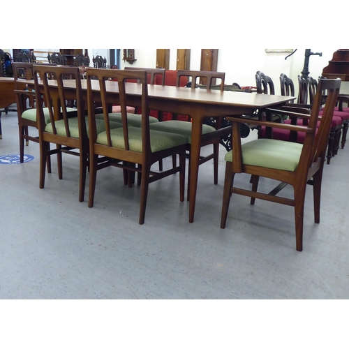 296 - A 1970s/1980s teak dining table, the one piece top with sides, raised on turned, tapered legs  29.5