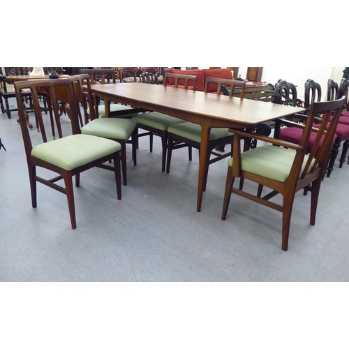 296 - A 1970s/1980s teak dining table, the one piece top with sides, raised on turned, tapered legs  29.5