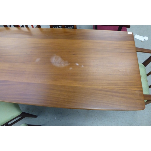 296 - A 1970s/1980s teak dining table, the one piece top with sides, raised on turned, tapered legs  29.5