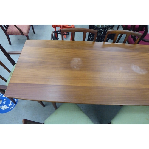 296 - A 1970s/1980s teak dining table, the one piece top with sides, raised on turned, tapered legs  29.5