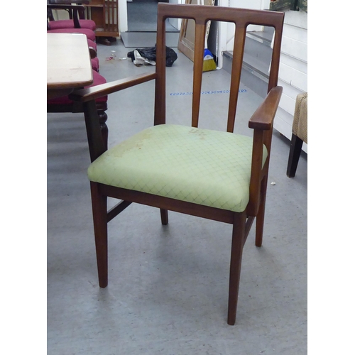 296 - A 1970s/1980s teak dining table, the one piece top with sides, raised on turned, tapered legs  29.5