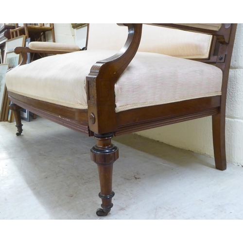 100 - An Edwardian mahogany showwood framed, two person settee, upholstered in patterned fabric, raised on... 