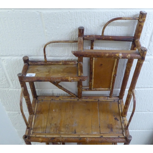 104 - A 20thC bamboo and pine panelled display stand with offset, graduated open shelves  54