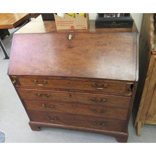 106 - An early 19thC mahogany bureau with a fall flap, over four graduated drawers, raised on bracket feet... 