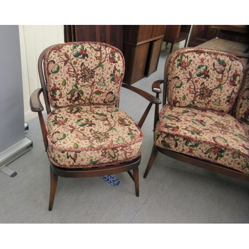 107 - An Ercol dark stained beech and elm framed, hoop and spindle back, three piece suite with floral pat... 