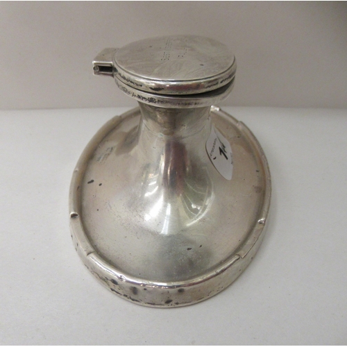 144 - A silver capstan design inkwell of oval form with a hinged lid  Birmingham marks rubbed  6... 