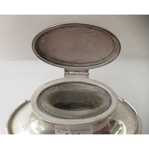 144 - A silver capstan design inkwell of oval form with a hinged lid  Birmingham marks rubbed  6... 