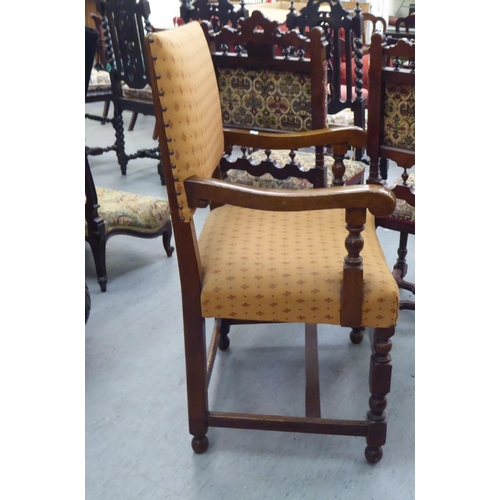 168 - A 20thC Cromwellian style oak framed dining chair with an upholstered back and seat, raised on turne... 