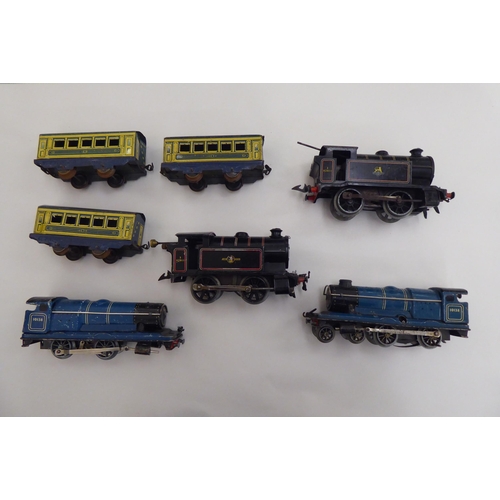 190 - Four 0 gauge, tinplate clockwork model railway locomotives and three matching passenger coaches