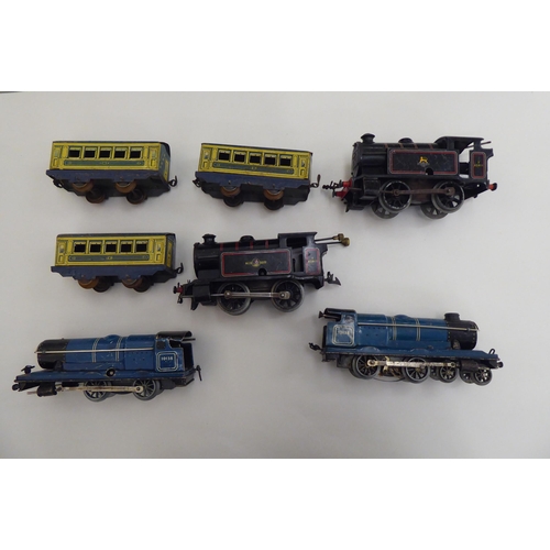 190 - Four 0 gauge, tinplate clockwork model railway locomotives and three matching passenger coaches