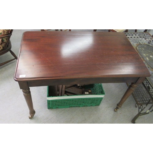 200 - A Victorian style mahogany serving table, raised on turned, tapered legs and brass cup casters  28