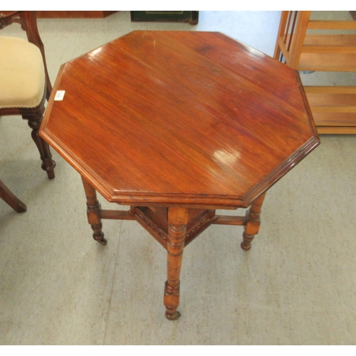 210 - An Edwardian mahogany octagonal occasional table, raised on turned legs, united by a galleried under... 