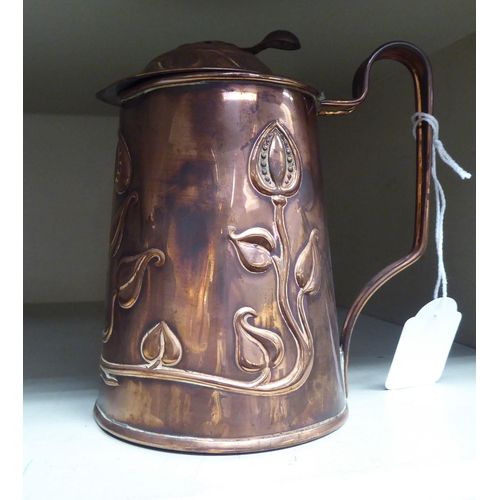 227 - An Art Nouveau period copper lidded jug, embossed with traditional floral designs  stamped Made in E... 