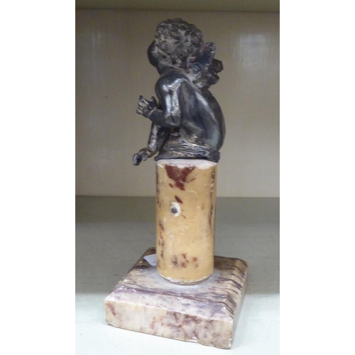 235 - A 20thC silver plated cherubic ornament, on a marble pedestal and square plinth  9.5