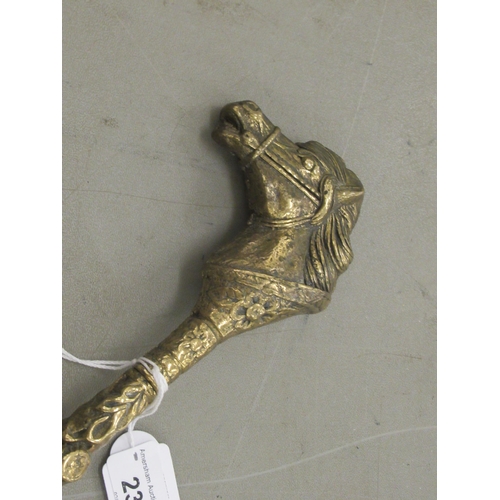 237 - A mid 20thC cast brass shoe horn with an equestrian themed handles  20