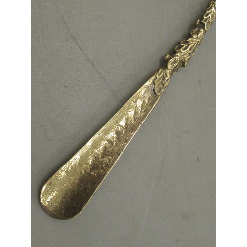 237 - A mid 20thC cast brass shoe horn with an equestrian themed handles  20