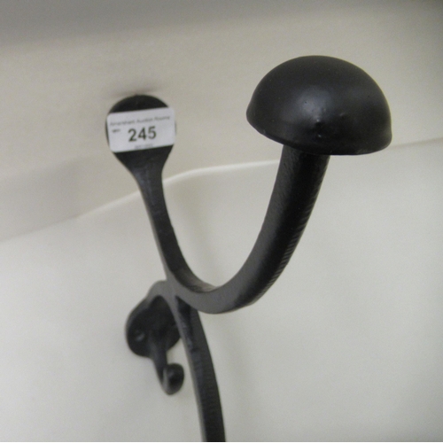 245 - A modern replica of a Victorian Parisian hotel, black painted wall mounted metal valet bracket