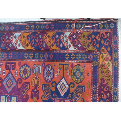 24 - A Persian rug, decorated with repeating design, in bright colours  60