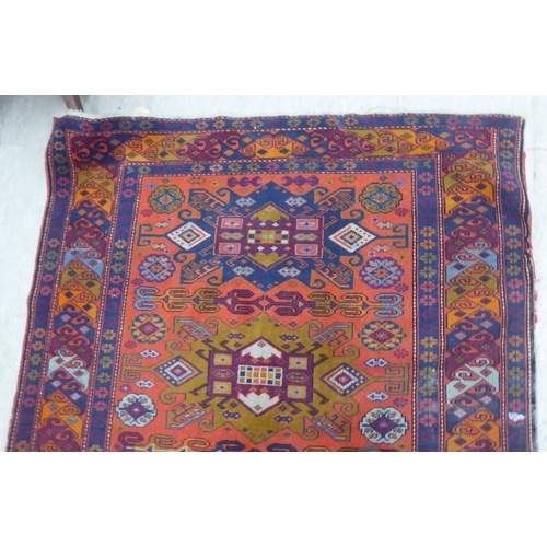 24 - A Persian rug, decorated with repeating design, in bright colours  60