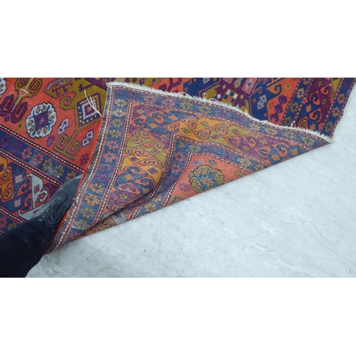 24 - A Persian rug, decorated with repeating design, in bright colours  60