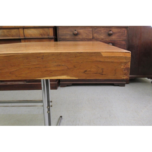 275 - In the manner of Heals, a 1970s rosewood veneered draw action dining table, raised on a cast metal a... 