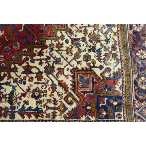 37 - A Persian carpet, decorated with repeating stylised designs, on a multi-coloured ground  94