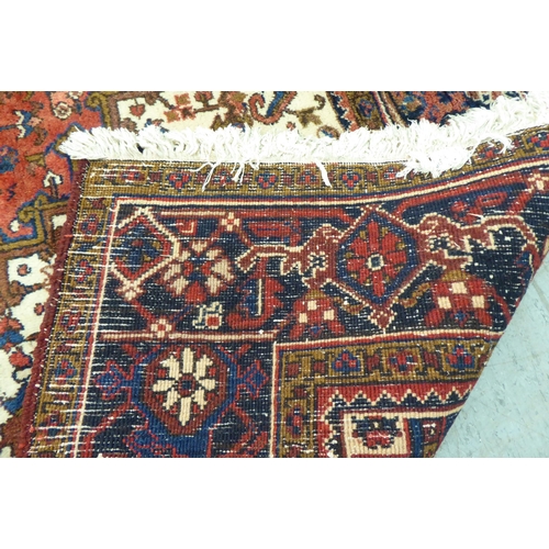 37 - A Persian carpet, decorated with repeating stylised designs, on a multi-coloured ground  94