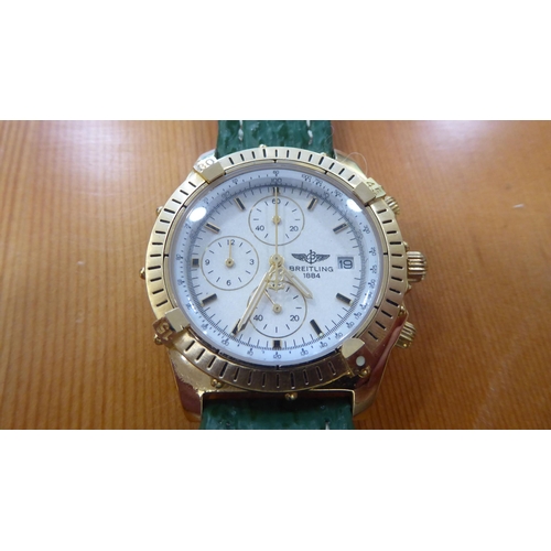 61 - A gold plated wristwatch, on a green hide strap