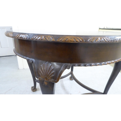 78 - A mid 20thC Georgian design stained and carved beech centre table, raised on shell carved cabriole l... 