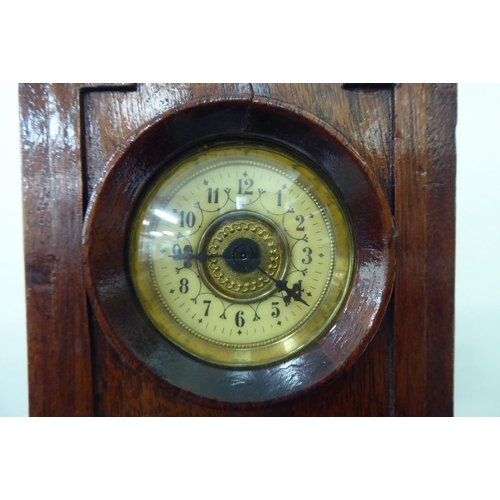 7 - An early 20thC mahogany mantel timepiece, fashioned as a longcase clock with an arched hood and stra... 