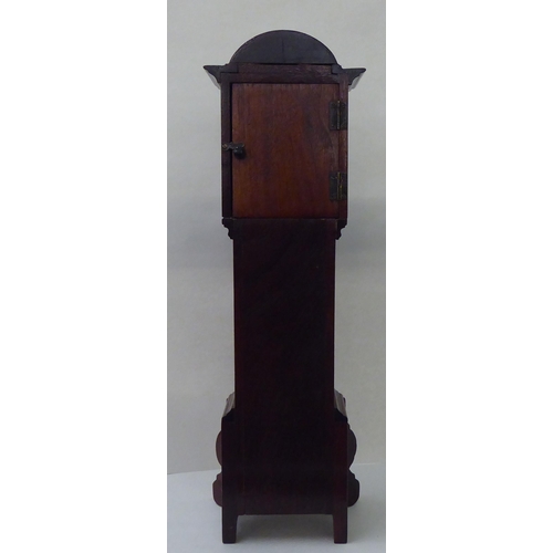 7 - An early 20thC mahogany mantel timepiece, fashioned as a longcase clock with an arched hood and stra... 