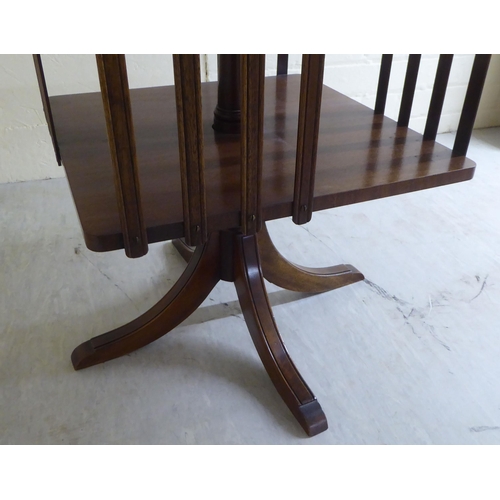 86 - A 20thC reproduction of a Georgian mahogany framed revolving bookcase, on splayed feet  22