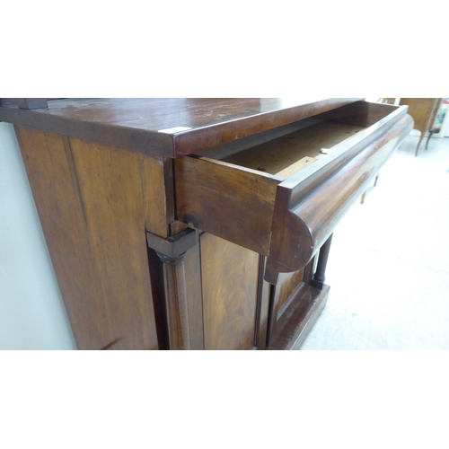 93 - A mid Victorian mahogany chiffonier with an open upstand, over a frieze and a pair of panelled doors... 