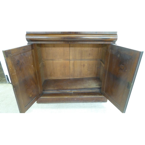 93 - A mid Victorian mahogany chiffonier with an open upstand, over a frieze and a pair of panelled doors... 