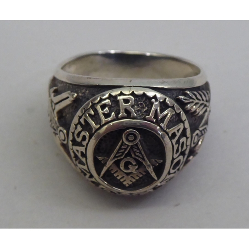 30 - A gentleman's silver ring, decorated with Masonic devices