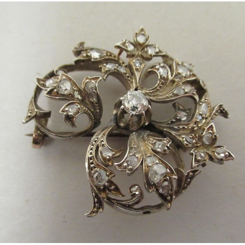 204 - A yellow metal floral brooch, set with diamonds