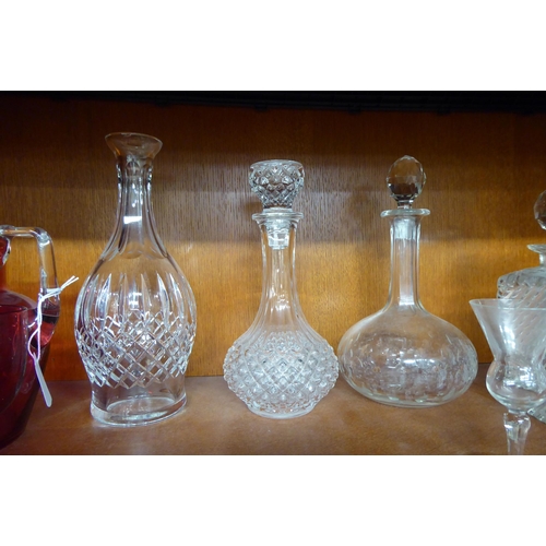 12 - Glassware: to include a clear and cranberry coloured cordial jug and six decanters