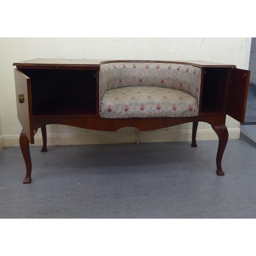 11 - A 1970/1980s mahogany finished telephone seat with a concave Art Nouveau inspired, fabric upholstere... 