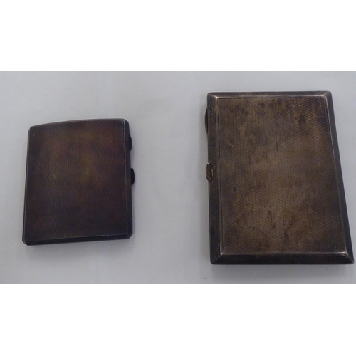 131 - Two similar silver folding cigarette cases, on button clasps  mixed marks