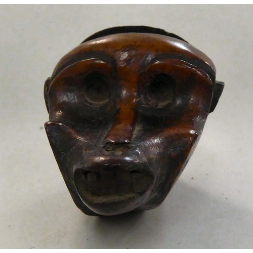 135 - An 18thC walnut novelty snuff box, naively carved as a monkeys head with a hinged lid