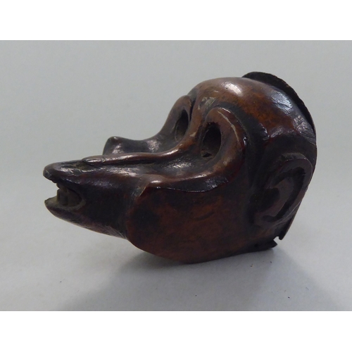 135 - An 18thC walnut novelty snuff box, naively carved as a monkeys head with a hinged lid