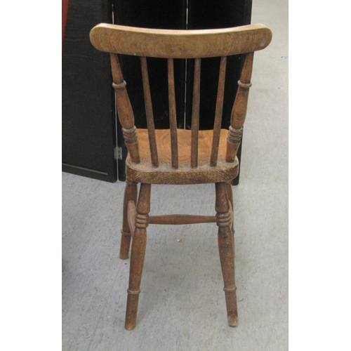 145 - A child's early 20thC Windsor beech and elm framed chair, the solid seat raised on ring turned, tape... 