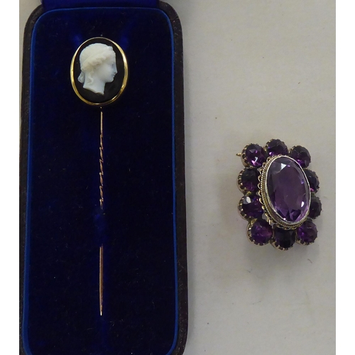 169 - A gold coloured metal cameo stickpin  cased; and a brooch, set with amethyst coloured stones&nb... 